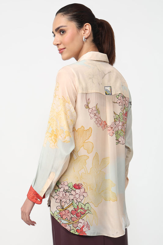 Woman wearing a floral patterned shirt with a neutral background