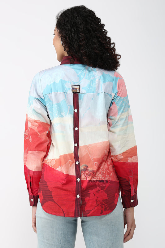 Person wearing a colorful patterned shirt on a white background