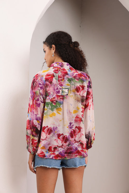 Woman wearing a colorful floral jacket against a neutral background