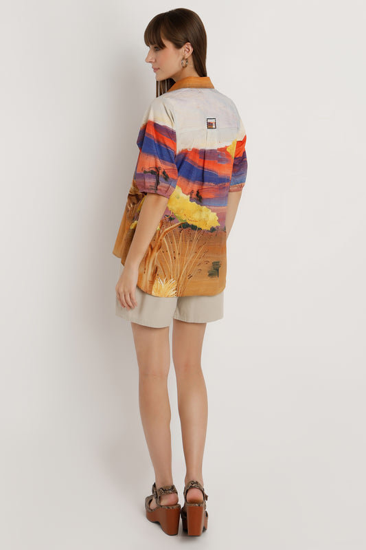 Person wearing a colorful shirt with abstract patterns on a plain background
