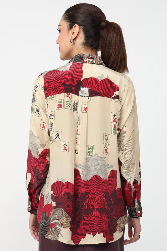 Woman wearing a shirt with a red and beige pattern on a white background