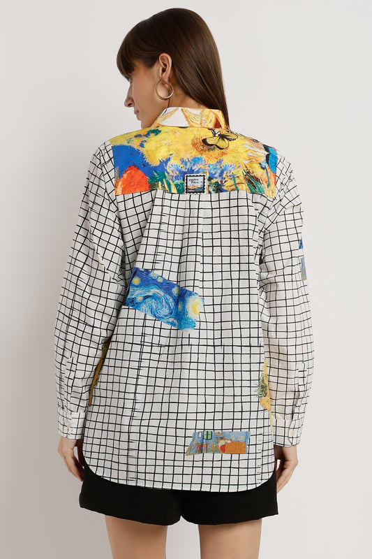 Woman wearing a checkered shirt with colorful floral and abstract designs on a plain background