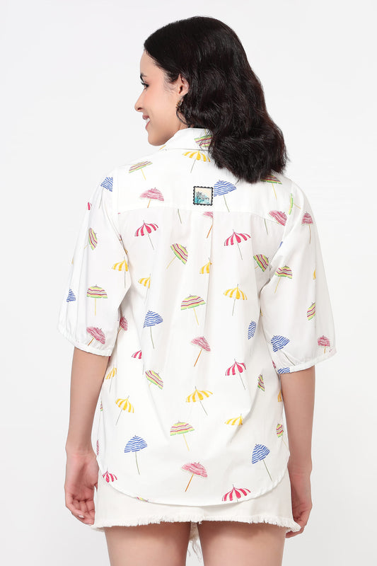 Woman wearing a white shirt with colorful floral pattern on a white background