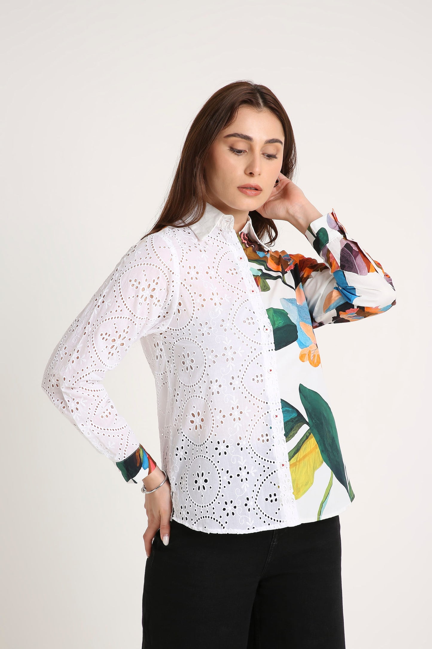 Woman wearing a white Shirt blouse with floral patterns on a plain background