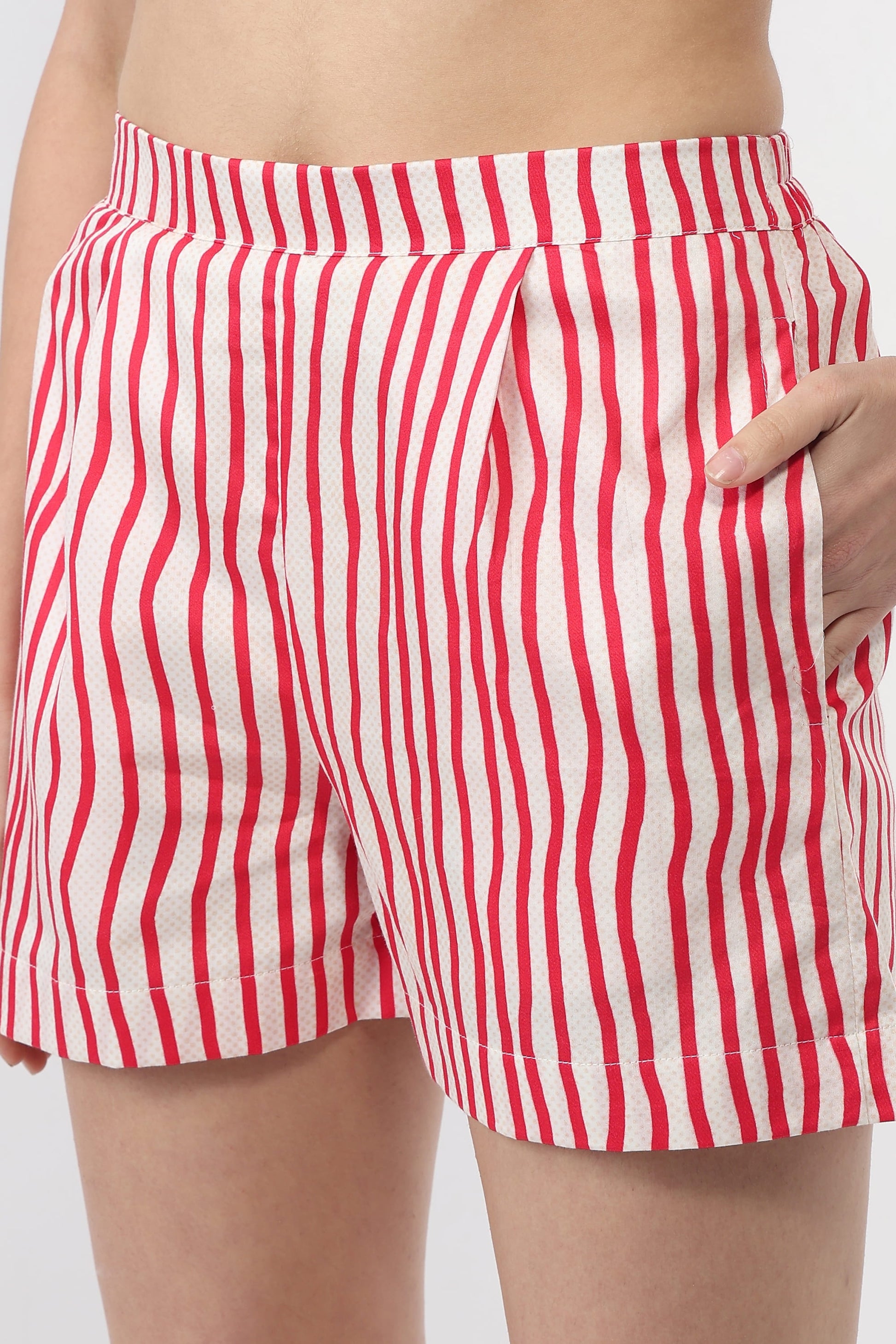 Red and white vertically striped shorts with side pockets, shown on a model from the waist to mid-thigh.
