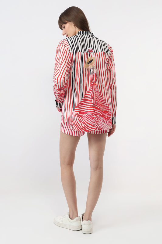 A model is shown from the back wearing a red, white, and black striped shirt and shorts set with white sneakers, photographed against a plain white studio background.