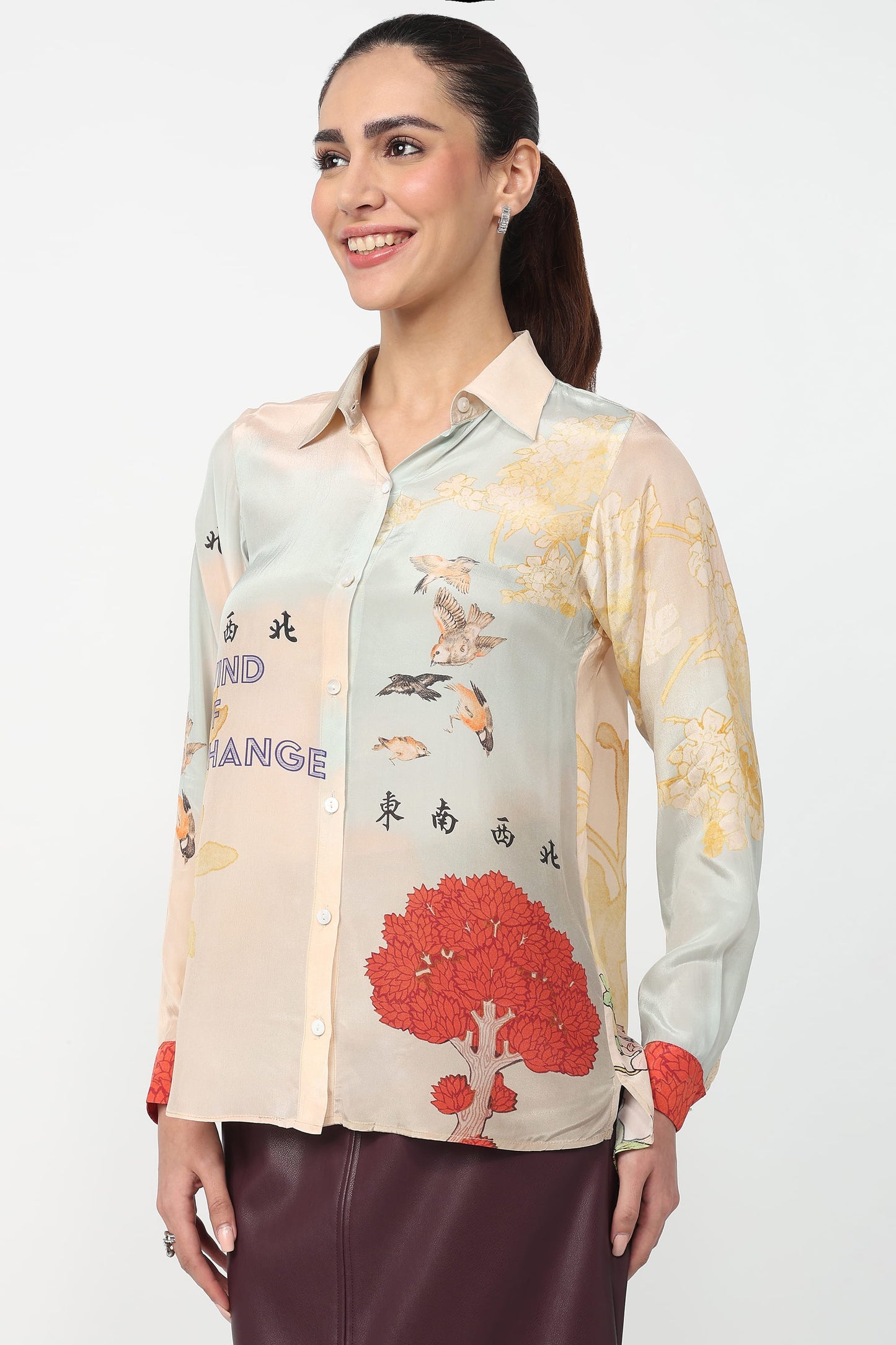 Woman wearing a colorful patterned shirt with a white background