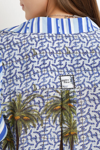 Close-up of a shirt with palm tree design and geometric pattern, brand logo visible.