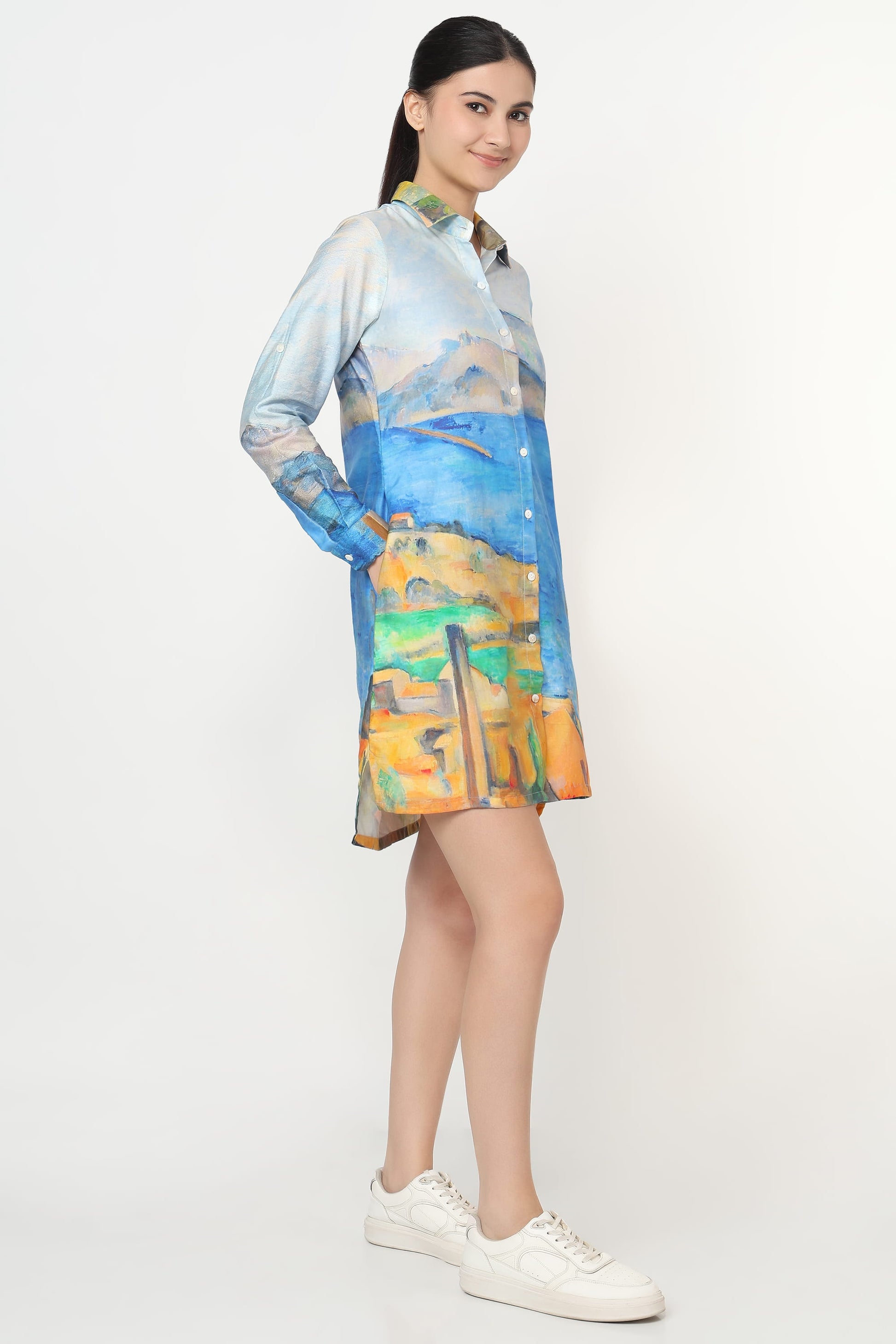 Woman wearing a colorful dress with abstract patterns on a white background
