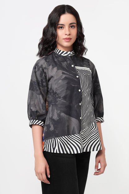 Woman wearing a black and white patterned shirt on a white background