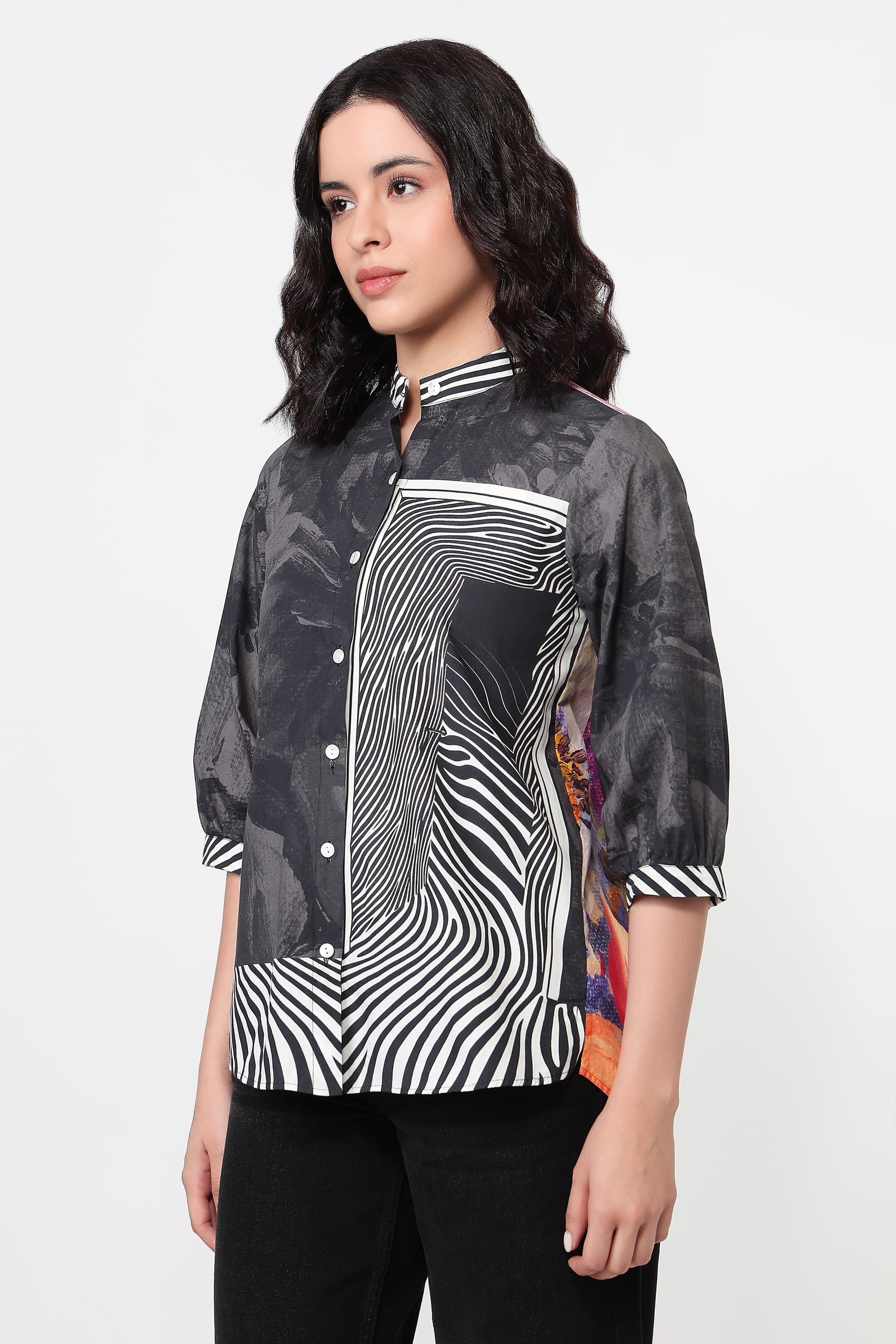 Woman wearing a black and white patterned shirt on a white background
