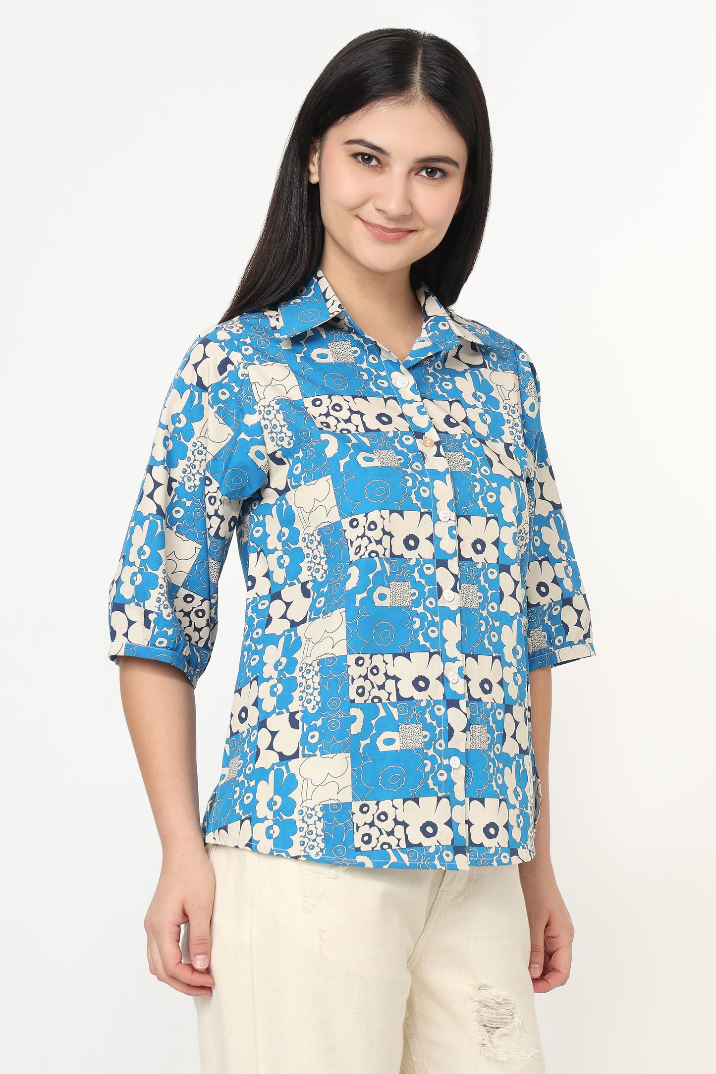 Woman wearing a blue floral patterned shirt on a white background