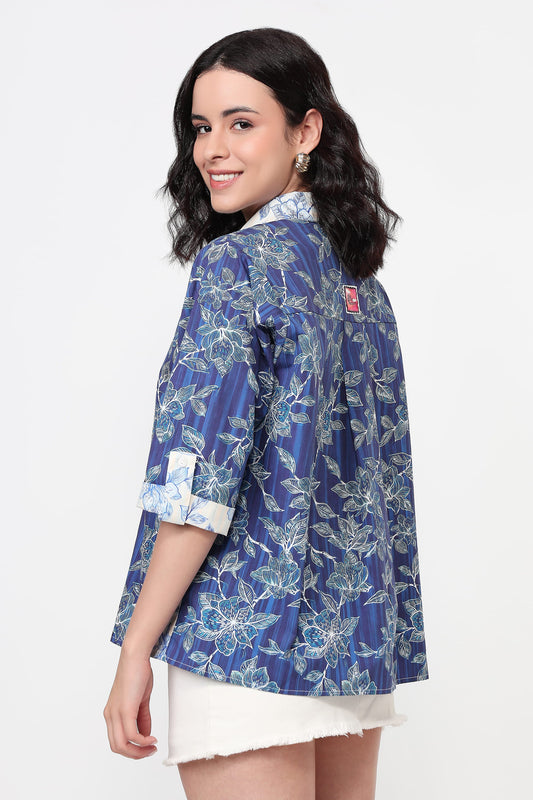 Woman wearing a blue floral patterned shirt on a white background