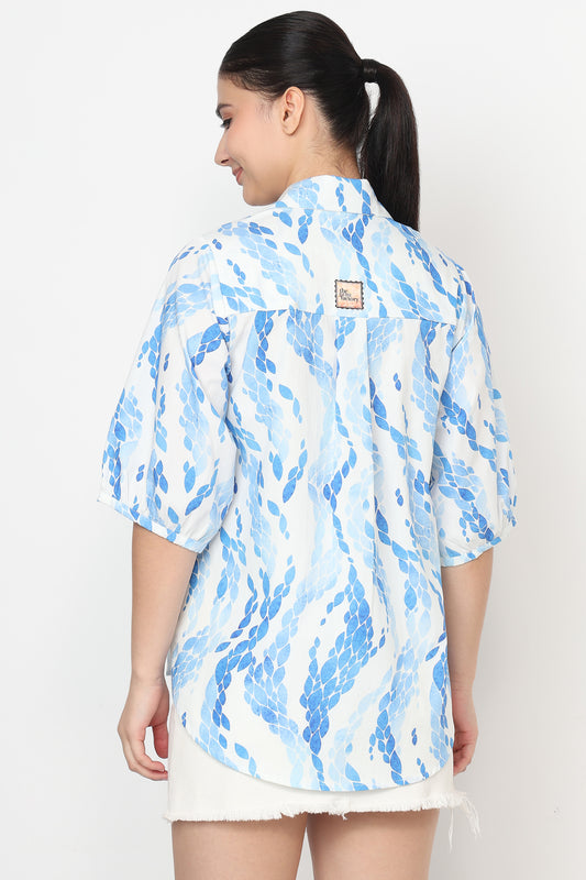 Woman wearing a blue and white patterned shirt on a white background