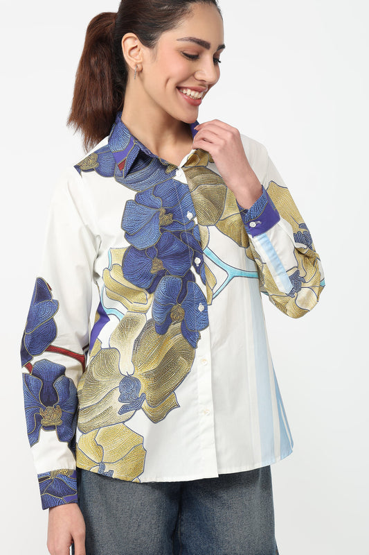 Woman wearing a white shirt with blue and green floral patterns on a white background