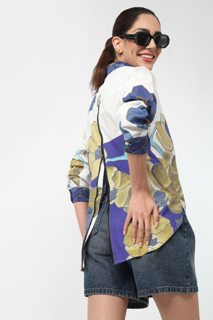 Woman wearing a colorful floral shirt and denim skirt on a white background