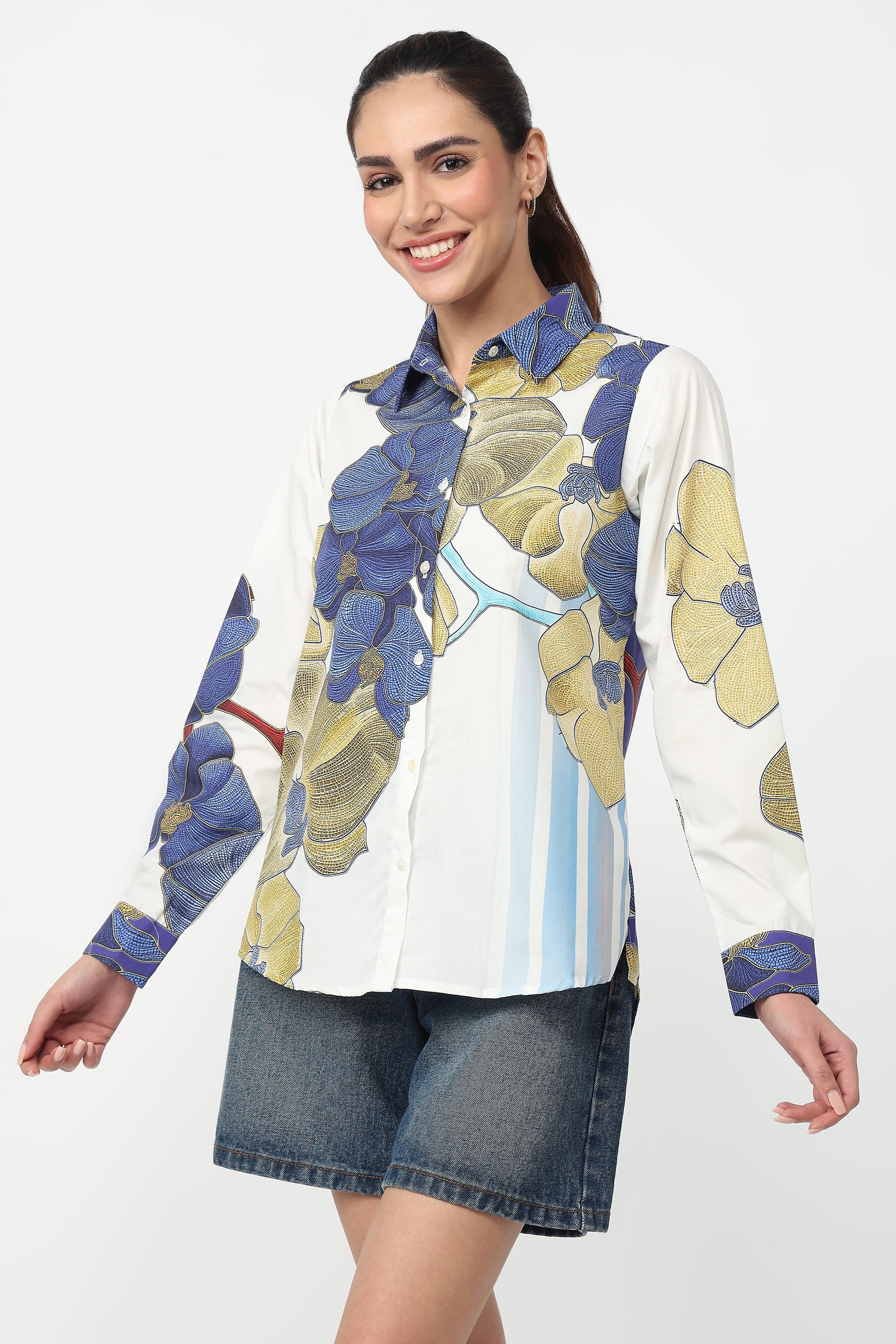 Woman wearing a colorful shirt with floral patterns on a white background