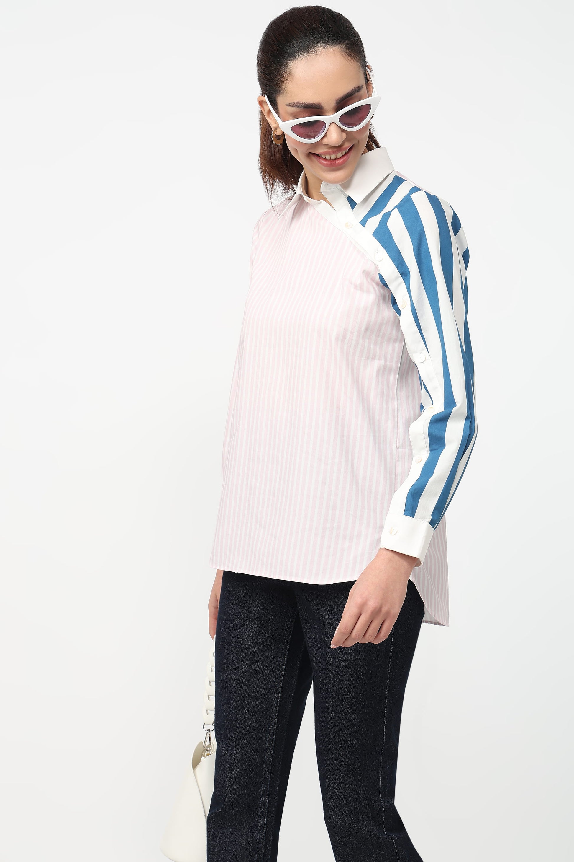 Woman wearing a white shirt with blue striped sleeves and black pants on a white background