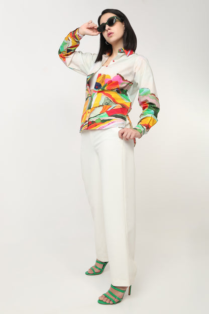 Person wearing a colorful patterned shirt and white pants on a white background