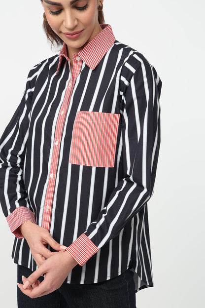 Woman wearing a black and white striped shirt with pink accents on a white background