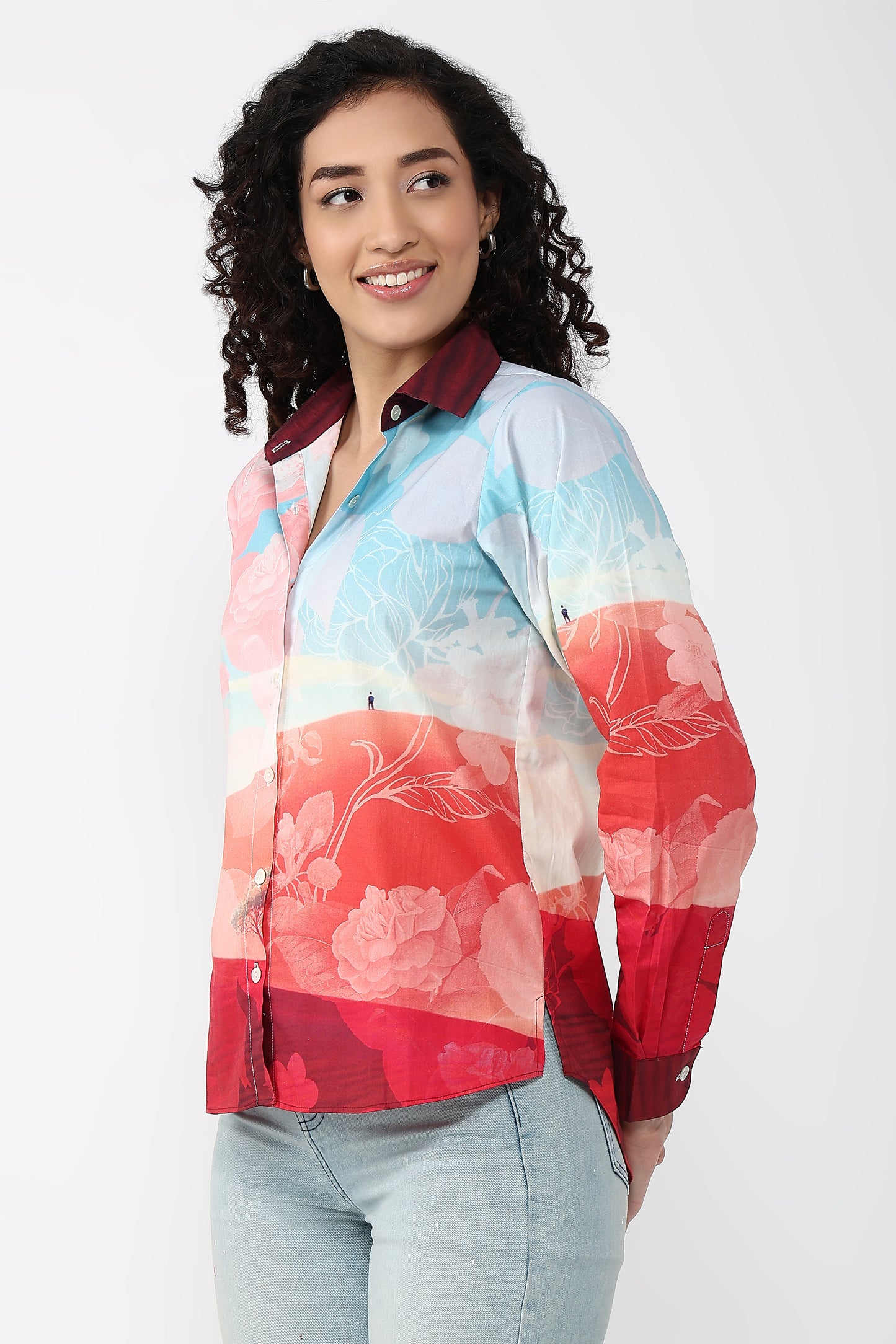 Woman wearing a colorful floral blouse with a plain background
