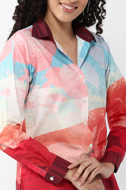 Woman wearing a colorful floral blouse with a red plaid collar on a white background