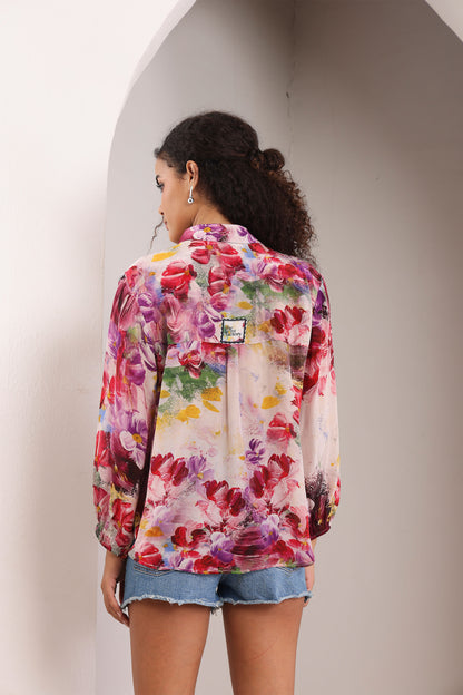 Woman wearing a colorful floral jacket against a neutral background