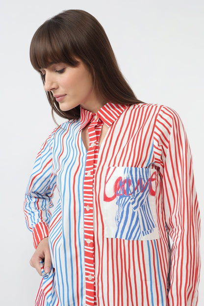 A woman wearing a long-sleeve button-up shirt with a red, white, and blue vertical stripe pattern, featuring a large graphic pocket on the front with the word 'Love' in red script.