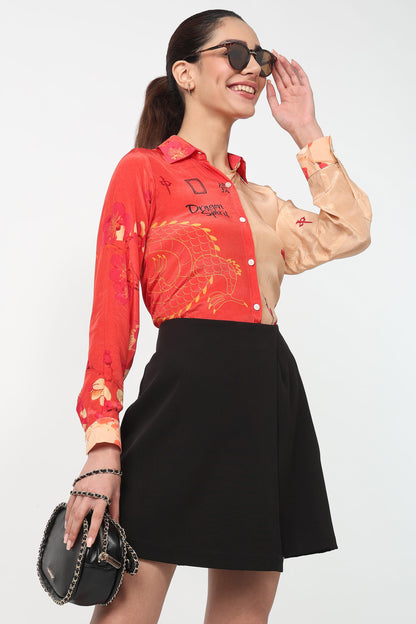 Woman wearing a red and beige patterned shirt with a black skirt on a white background