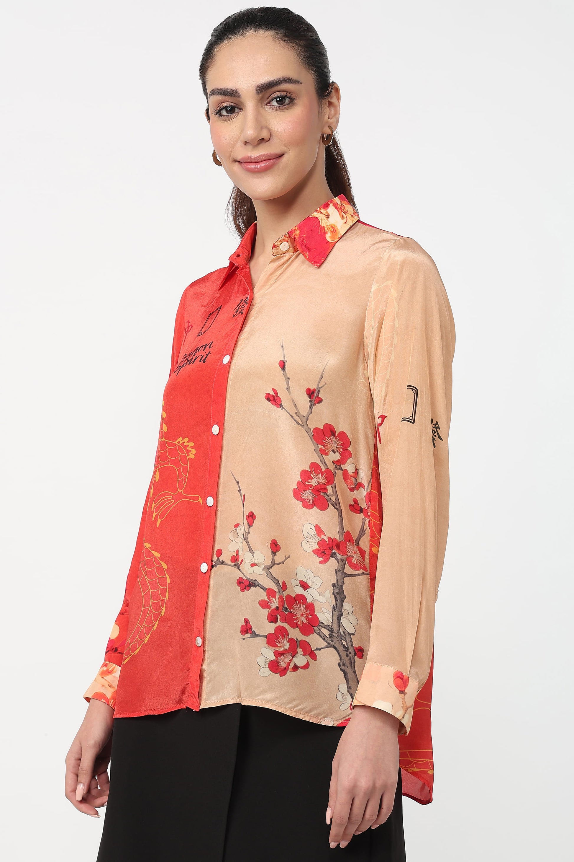 Woman wearing a red and beige floral shirt with a plain background