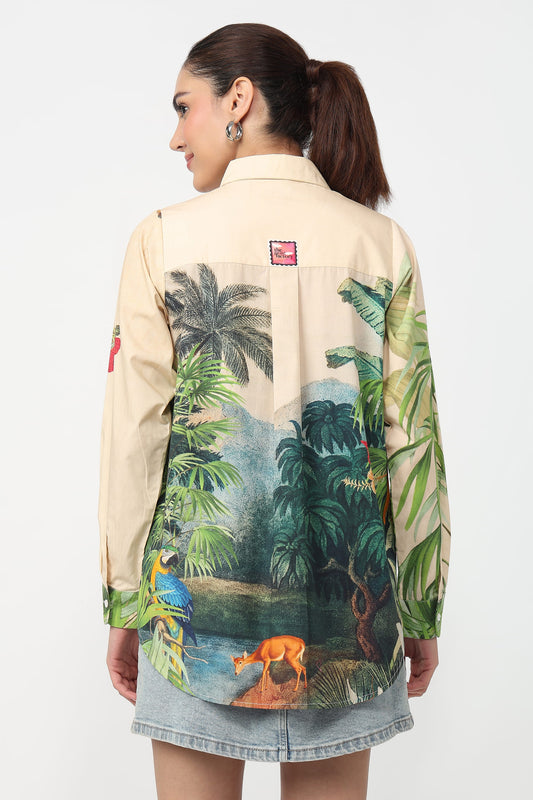 Person wearing a beige shirt with tropical print on a white background