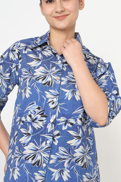 Person wearing a blue floral patterned shirt against a white background