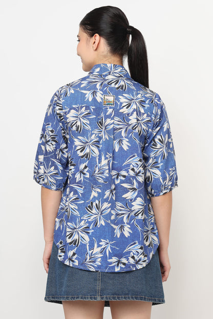 Woman wearing a blue floral patterned shirt on a white background