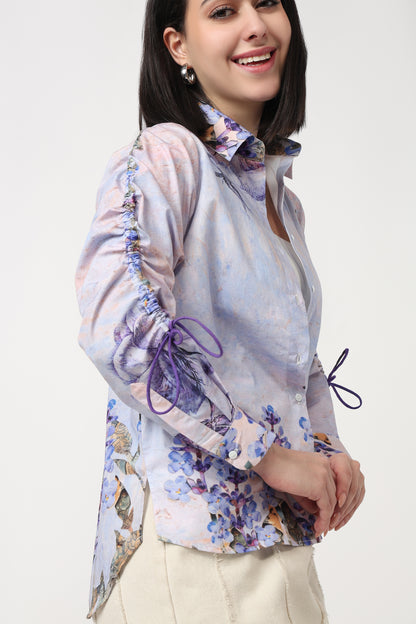 Woman wearing a floral blouse with long sleeves on a white background