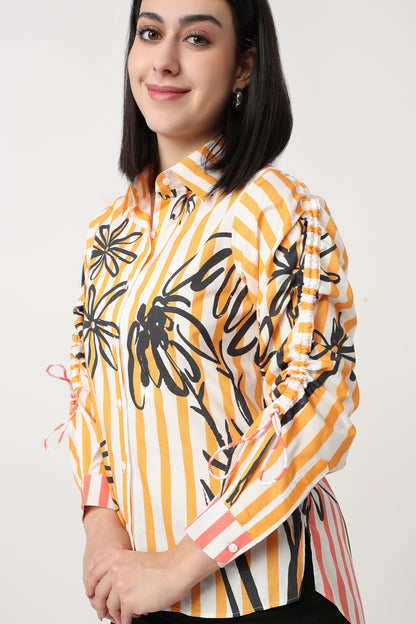 Woman wearing a colorful shirt with black floral patterns on a white background
