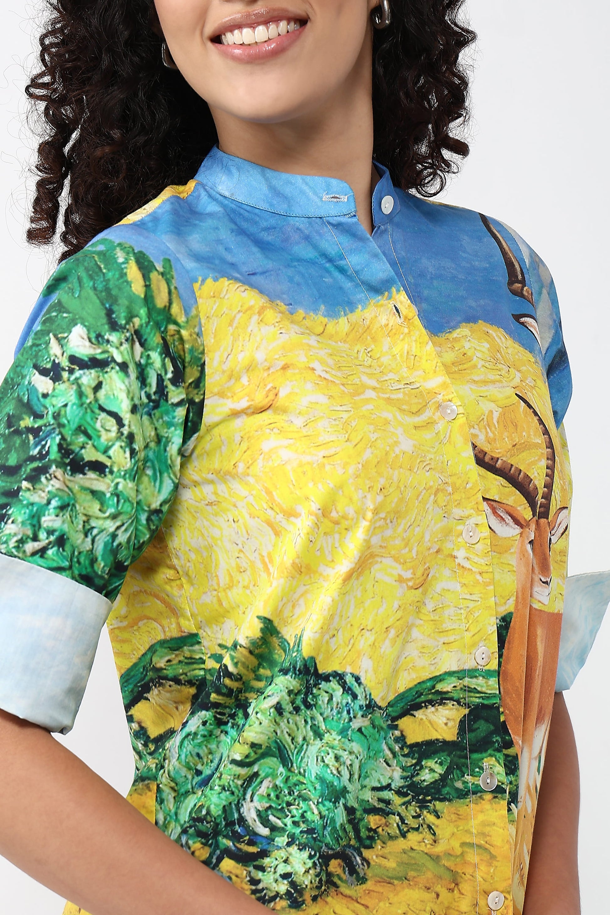 A close-up of a model wearing a short-sleeve button-up shirt with a vibrant art print featuring yellow, green, and blue colors, inspired by Van Gogh's style.