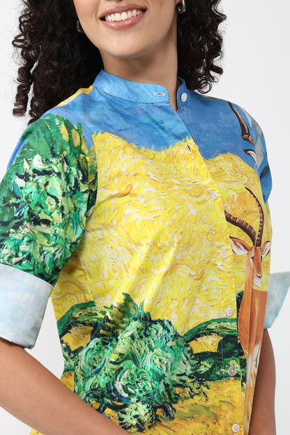 A close-up of a model wearing a short-sleeve button-up shirt with a vibrant art print featuring yellow, green, and blue colors, inspired by Van Gogh's style.