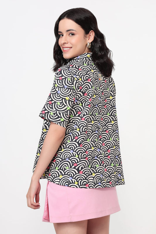 Woman wearing a patterned shirt and pink skirt on a white background