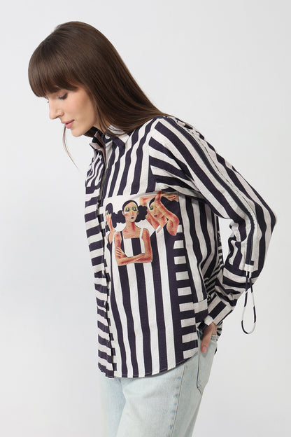 Woman wearing a black and white striped shirt with graphic designs on a white background