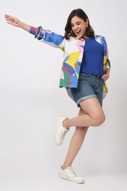 Woman wearing a colorful jacket and denim shorts on a white background
