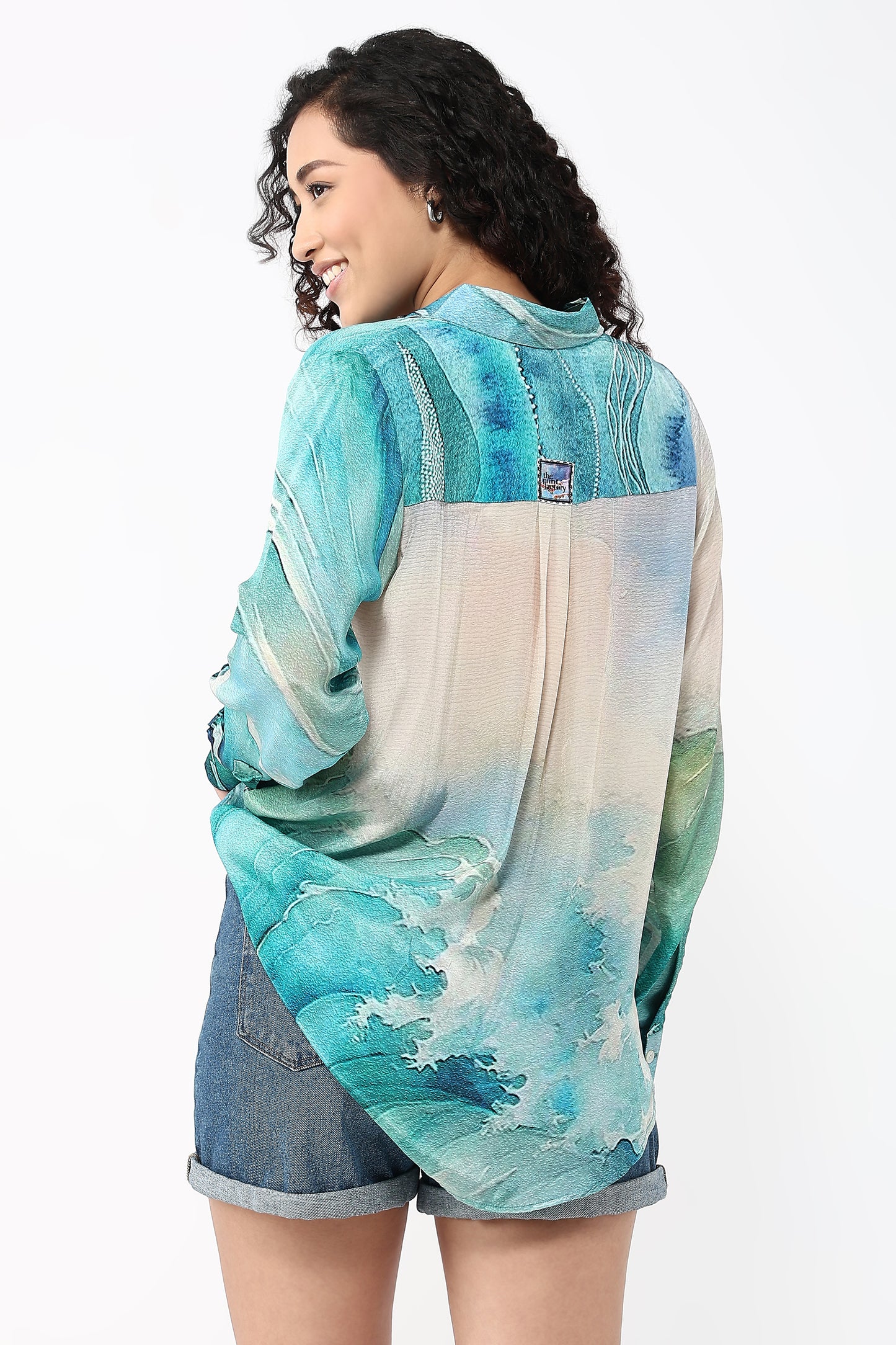Woman wearing a colorful shirt with a watercolor design on a white background