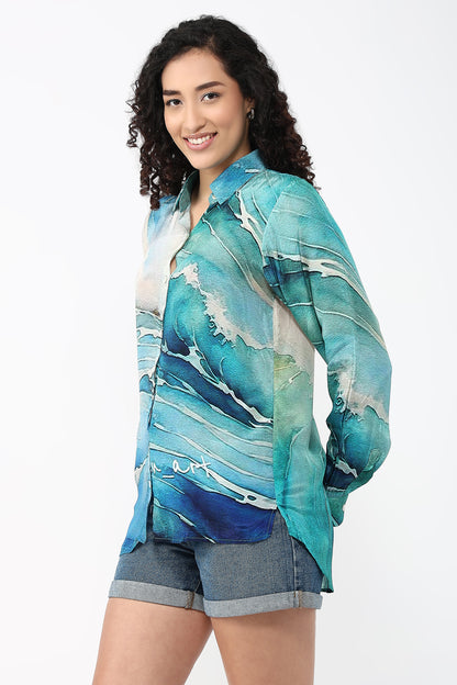 Woman wearing a blue and green abstract patterned shirt on a white background