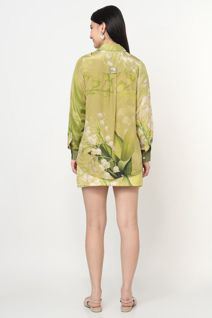 Woman wearing a green floral co-ord set on a white background