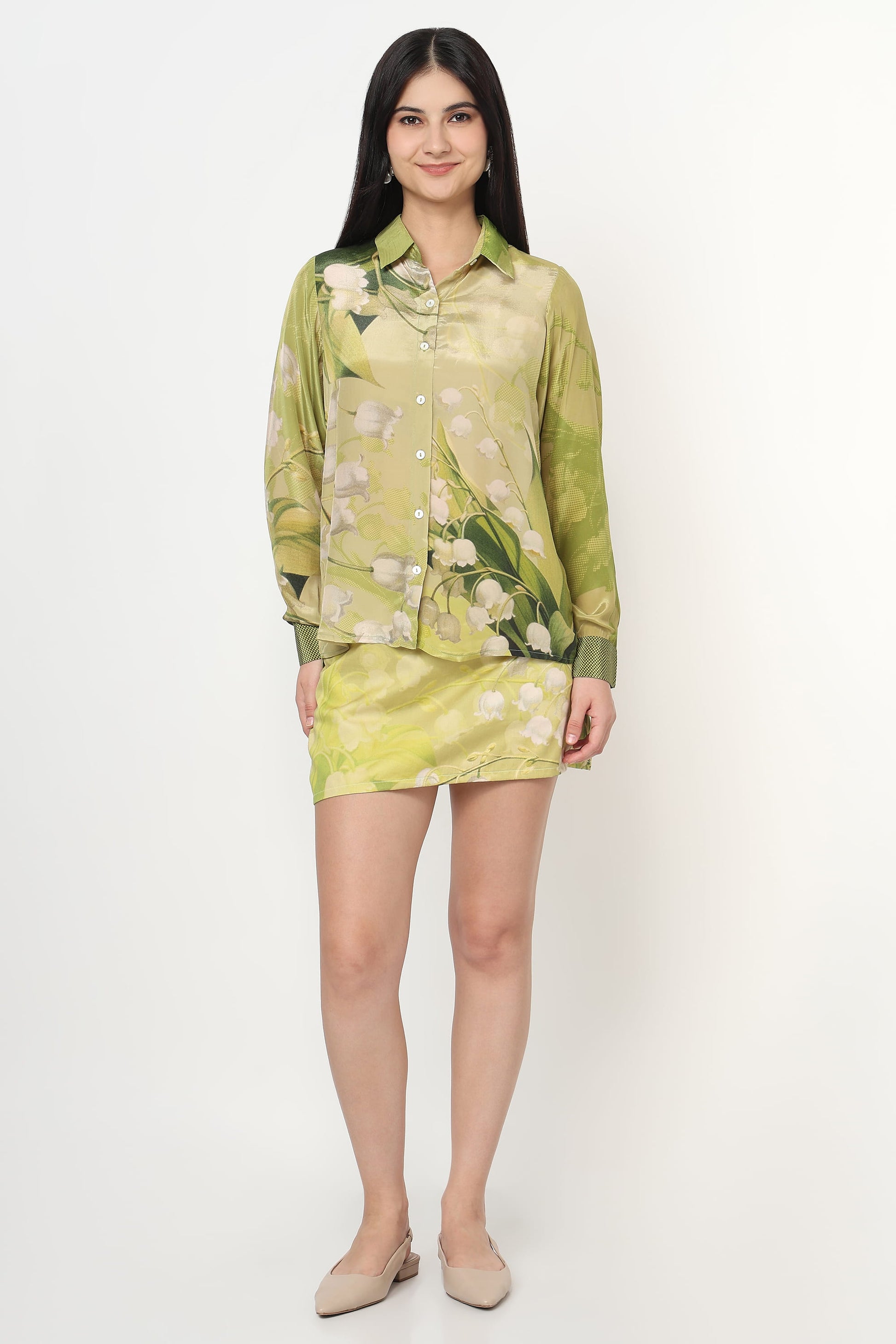 Woman wearing a green floral co-ord set on a white background
