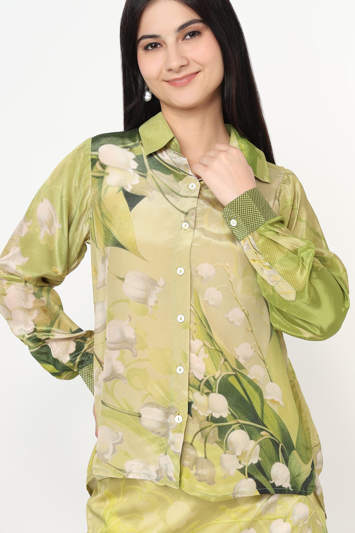 Woman wearing a green floral shirt against a white background