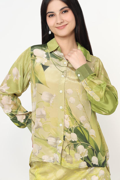 Woman wearing a green floral shirt against a white background