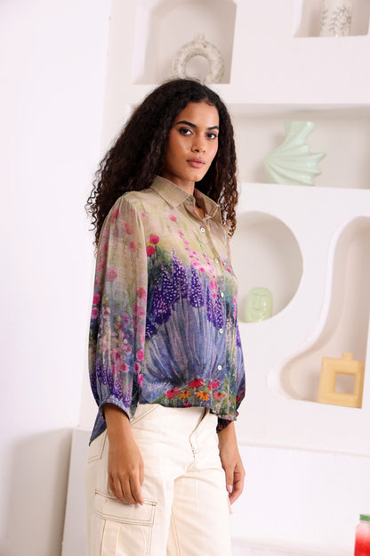 Woman wearing a colorful floral blouse in a minimal indoor setting