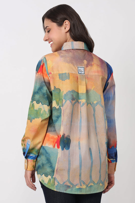 Woman wearing a colorful watercolor-style shirt on a white background
