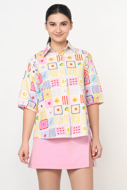 Woman wearing a colorful patterned shirt and pink skirt on a white background