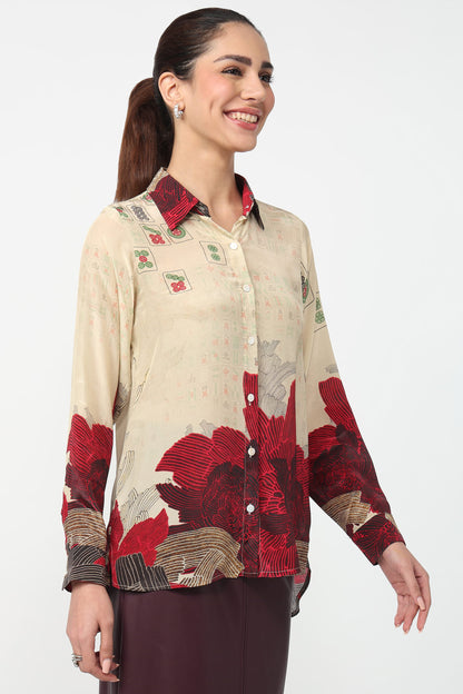 Woman wearing a patterned shirt with red and beige design on a white background